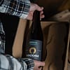 mains tenant une bière artisanale d'exception vieillie en fût de bois