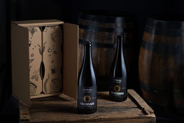 2 bières d'exception brasserie maddam posées sur une table en bois